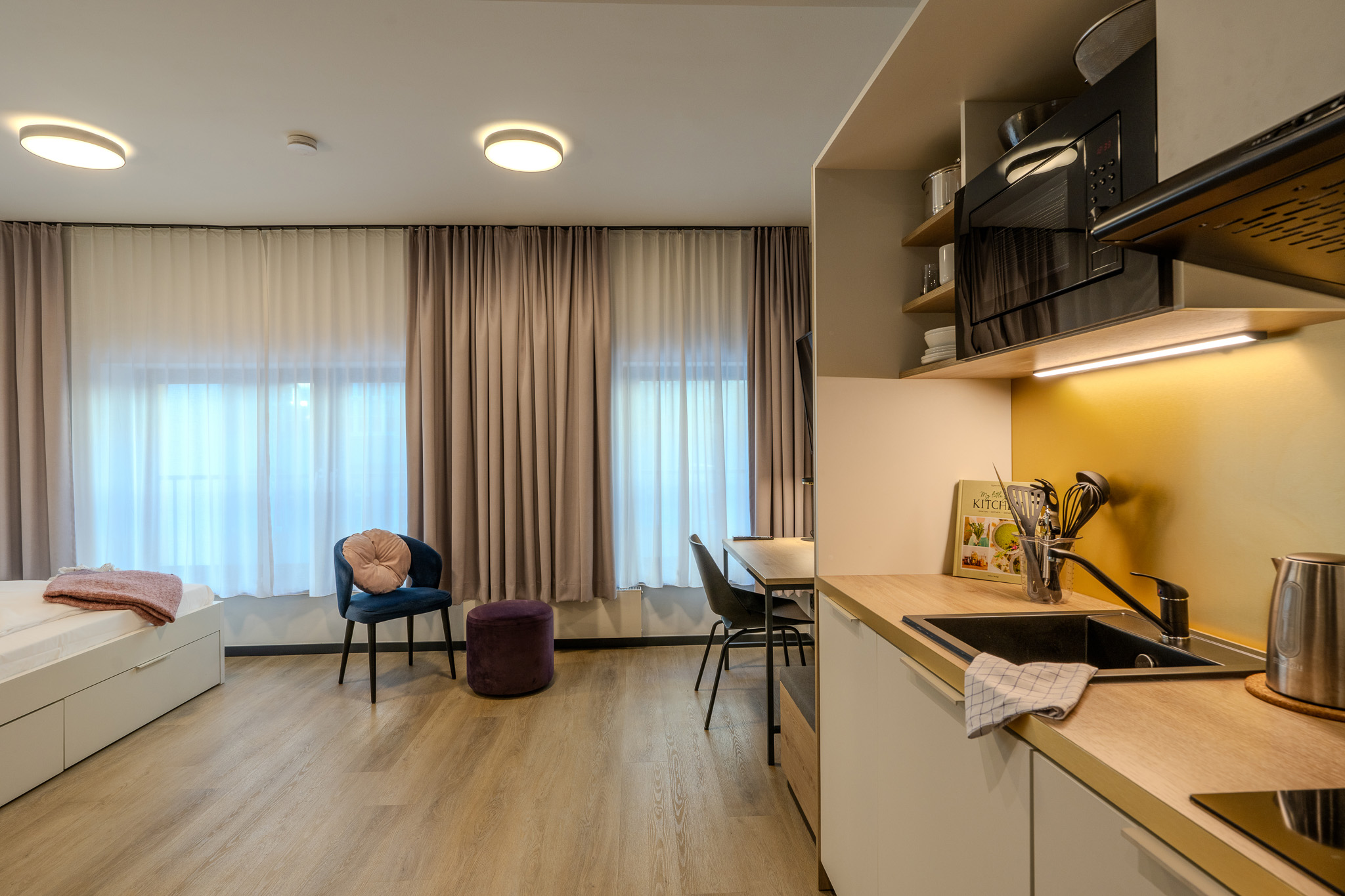 Ein Blick in den Wohnbereich des möblierten Zimmers im The Base Berlin