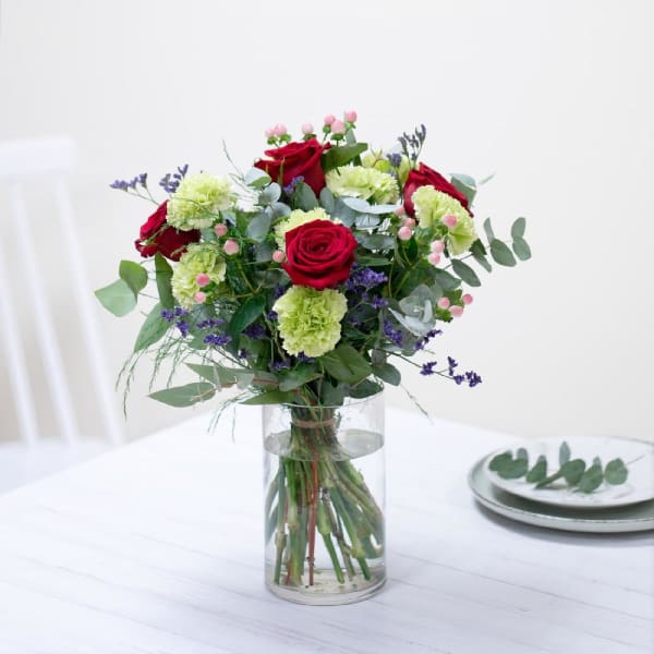 Mixed bouquet with red roses in warm and green tones