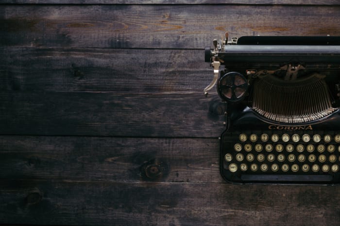 typewriter sitting on a wooden desk