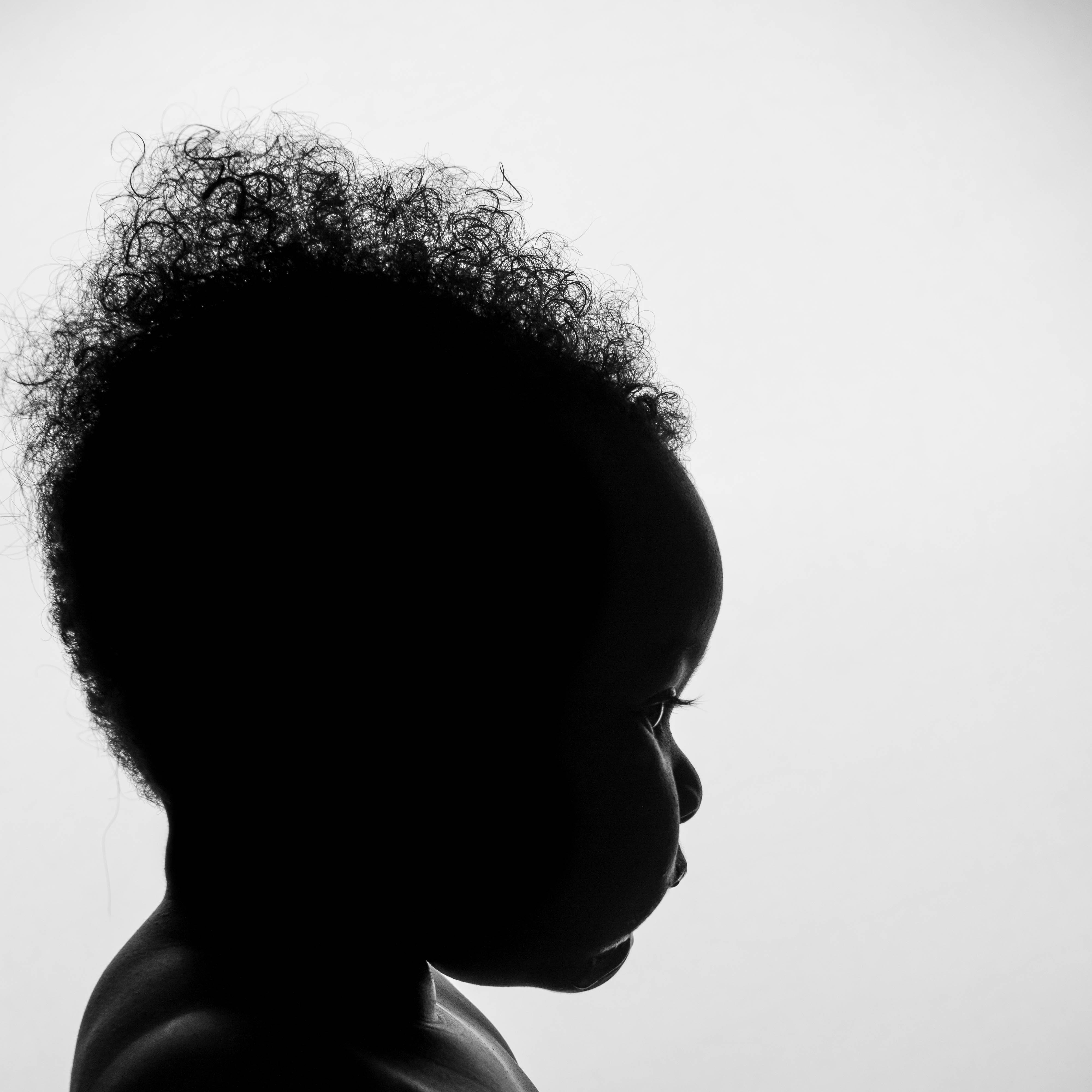 a silhouette of a man wearing glasses looking off to the right