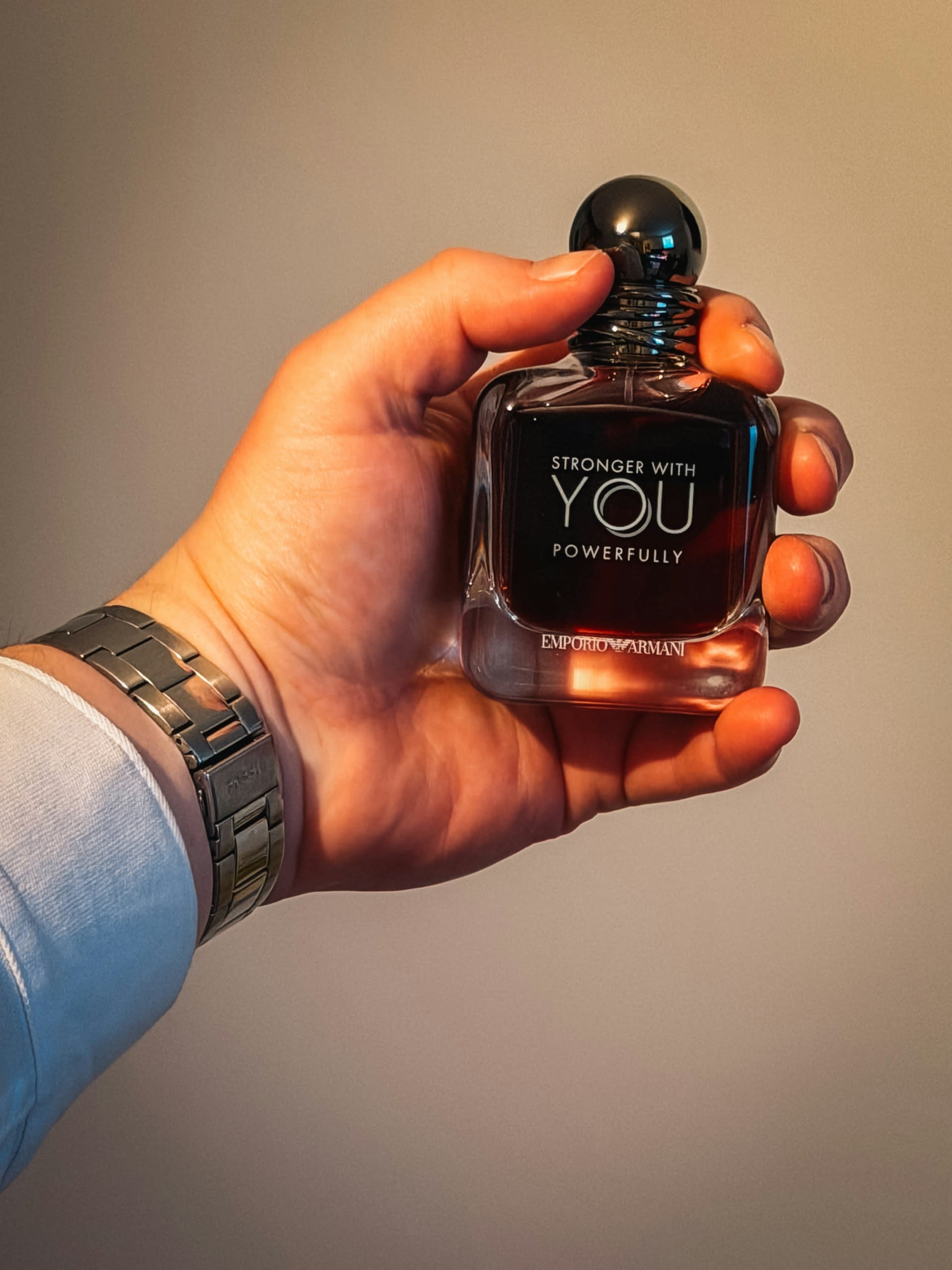 Un hombre sosteniendo un perfume