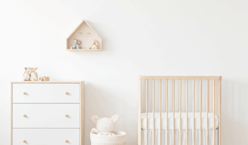 A clean nursery space with crib and dresser