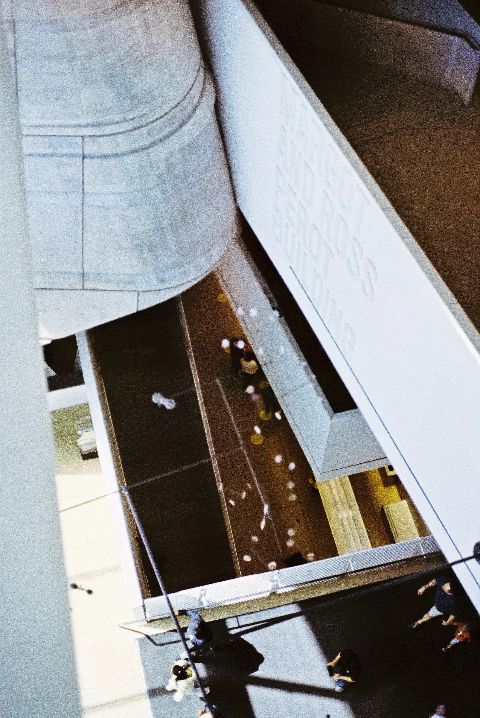 Overhead view of the Perot Museum interior with curved concrete walls and visitors on multiple levels below.