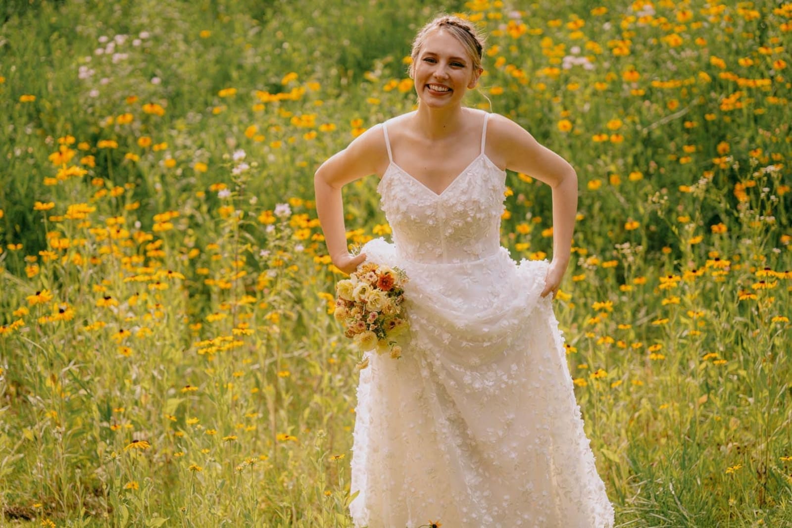 Hudson Valley bride smiling in a sunlit wildflower field at Troutbeck