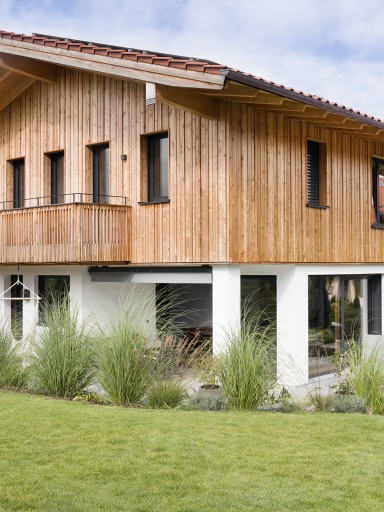 Modernes Einfamilienhaus im alpinen Stil mit klarer Holzarchitektur und großen Fensterflächen von Josko, die den Wohnraum mit der Natur verbinden.