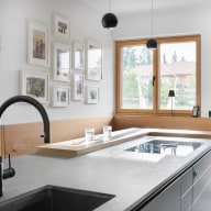 Helle Designküche mit großen Holzfenstern, klaren Linien und natürlichen Materialien – ein harmonischer Raum voller Licht, Wärme und moderner Eleganz.