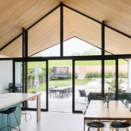 Heller Wohn- und Essbereich mit großer Glasfront von Josko, Holzdecke und direktem Zugang zur Terrasse mit Garten und Pool.