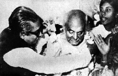 বঙ্গবন্ধু শেখ মুজিবুর রহমান কাজী নজরুল ইসলামকে ফুল দিয়ে সাদরে গ্রহণ করছেন