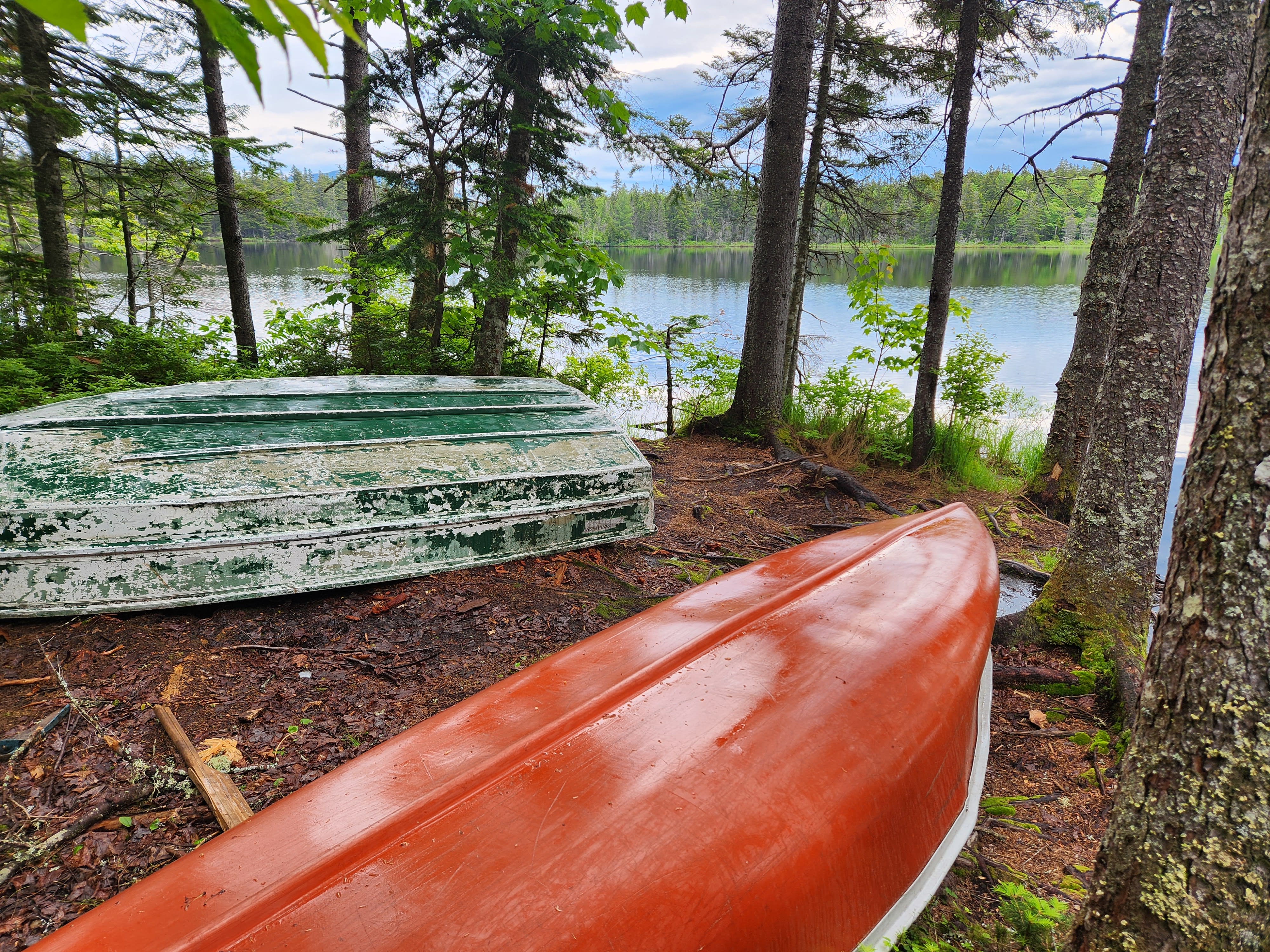Red canoe on lake shore