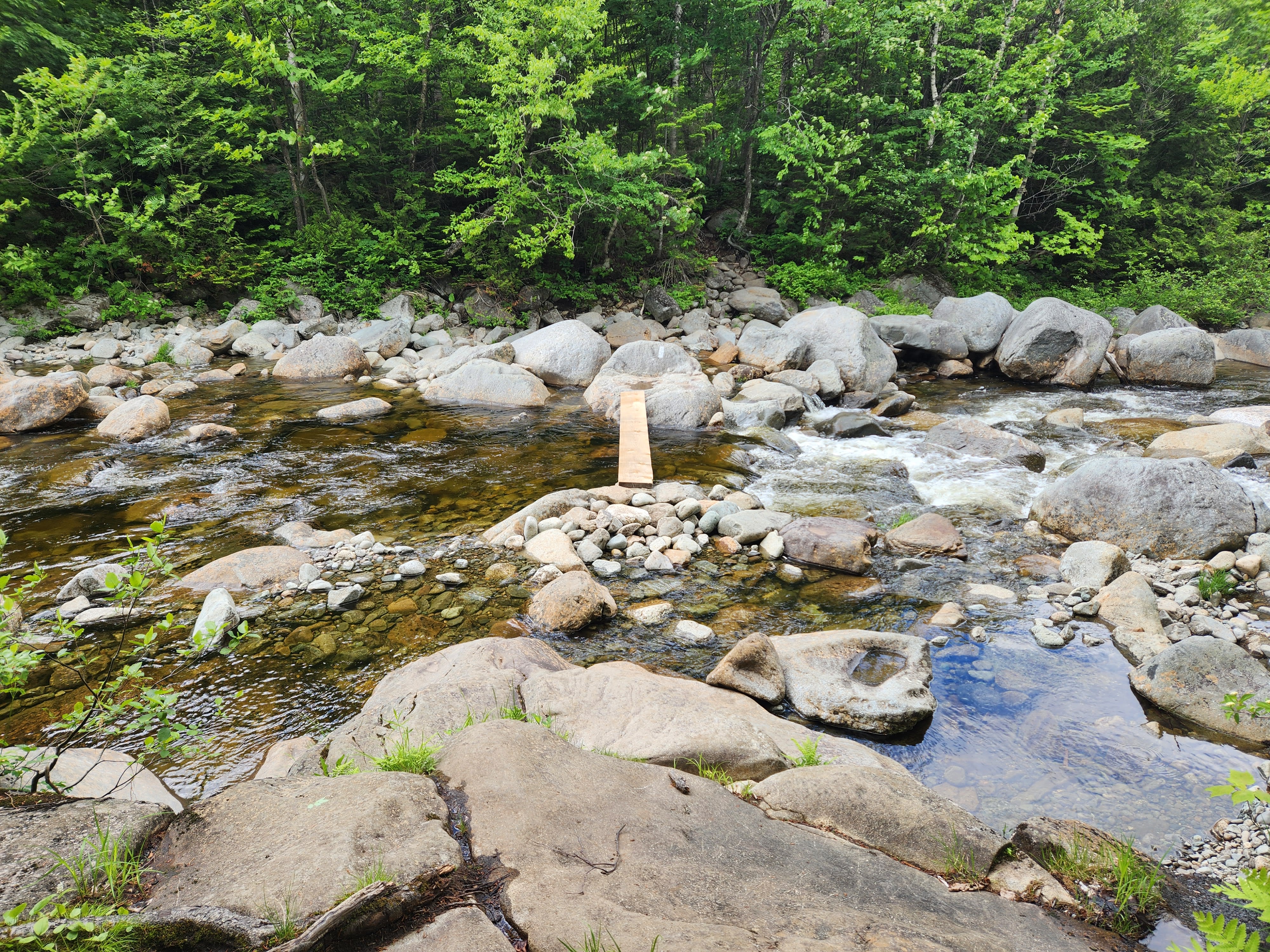 Narrow board over a rocky river