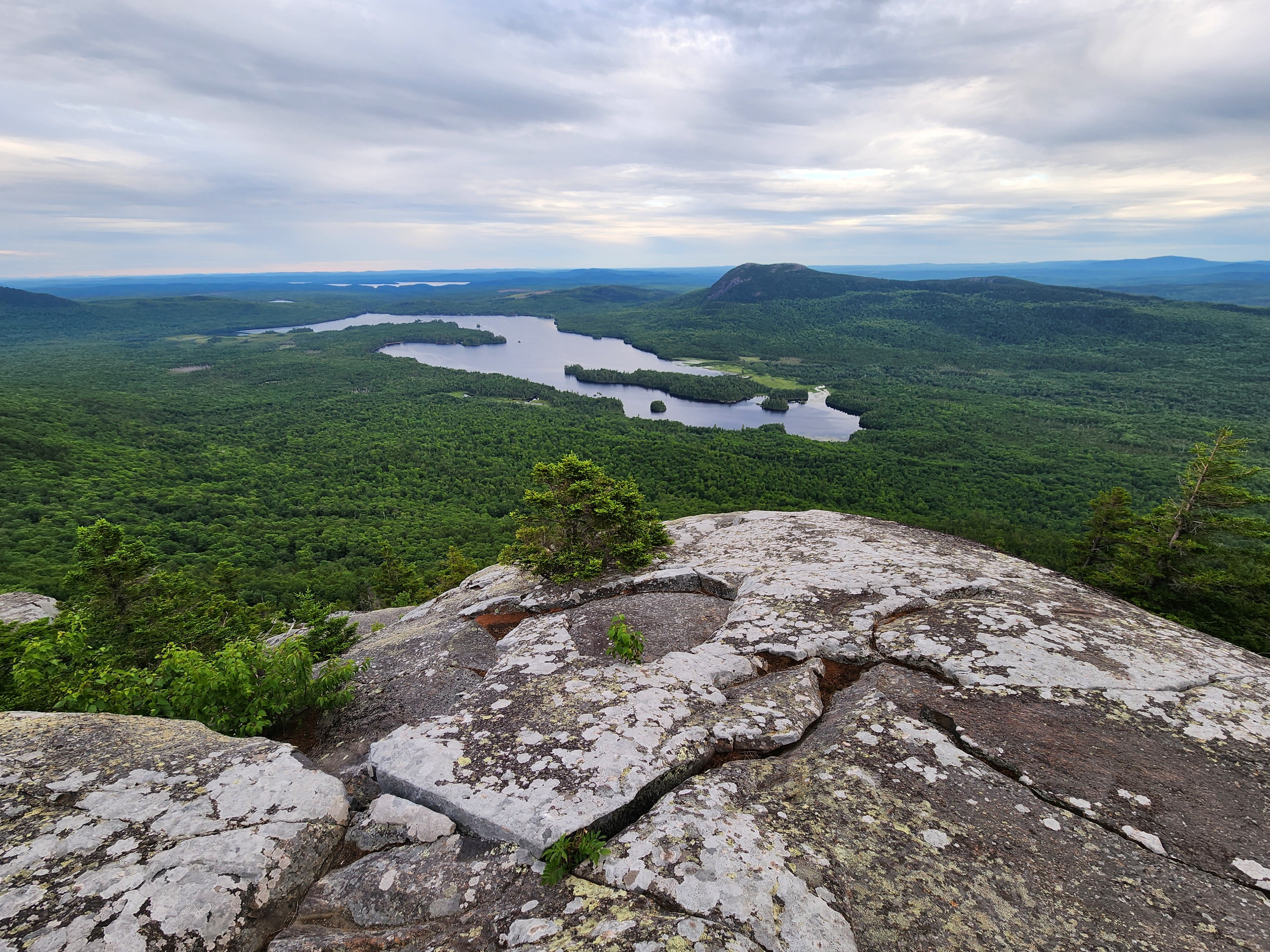 View of lakes and forests from rocky cliff