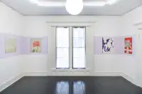 long shot of a gallery installation featuring 4 artworks on a purple striped wall with a large bay window in between