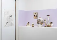 closeup of a drawing on a wall and seven sculptures on a shelf