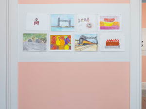 portrait shot of eight drawings on a gallery wall