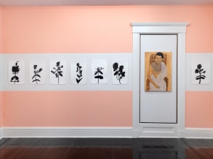 gallery installation of abstract flower paintings and a king-like figure