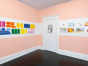 gallery installation of 18 drawings and paintings in the corner of a room
