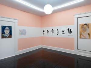 gallery installation of nine artworks in the corner of a room