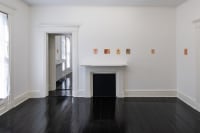 gallery installation of two oil paintings and three marker drawings on a shelf above a radiator