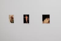 gallery installation of six drawings above a radiator and a small oil painting on the wall divided by a large bay window