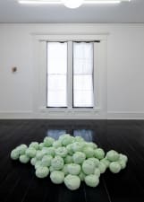 long shot of a gallery installation featuring 6 artworks with a large bay window in between and a couch
