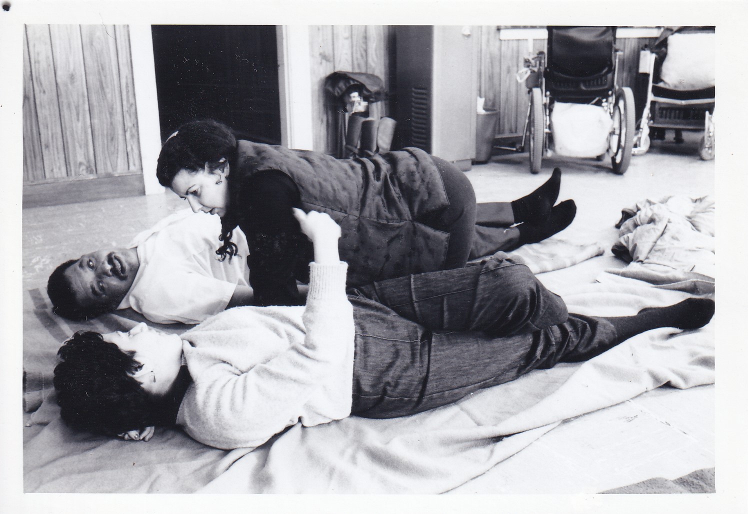 Loretta helping two clients on the floor with ayurvedic techniques