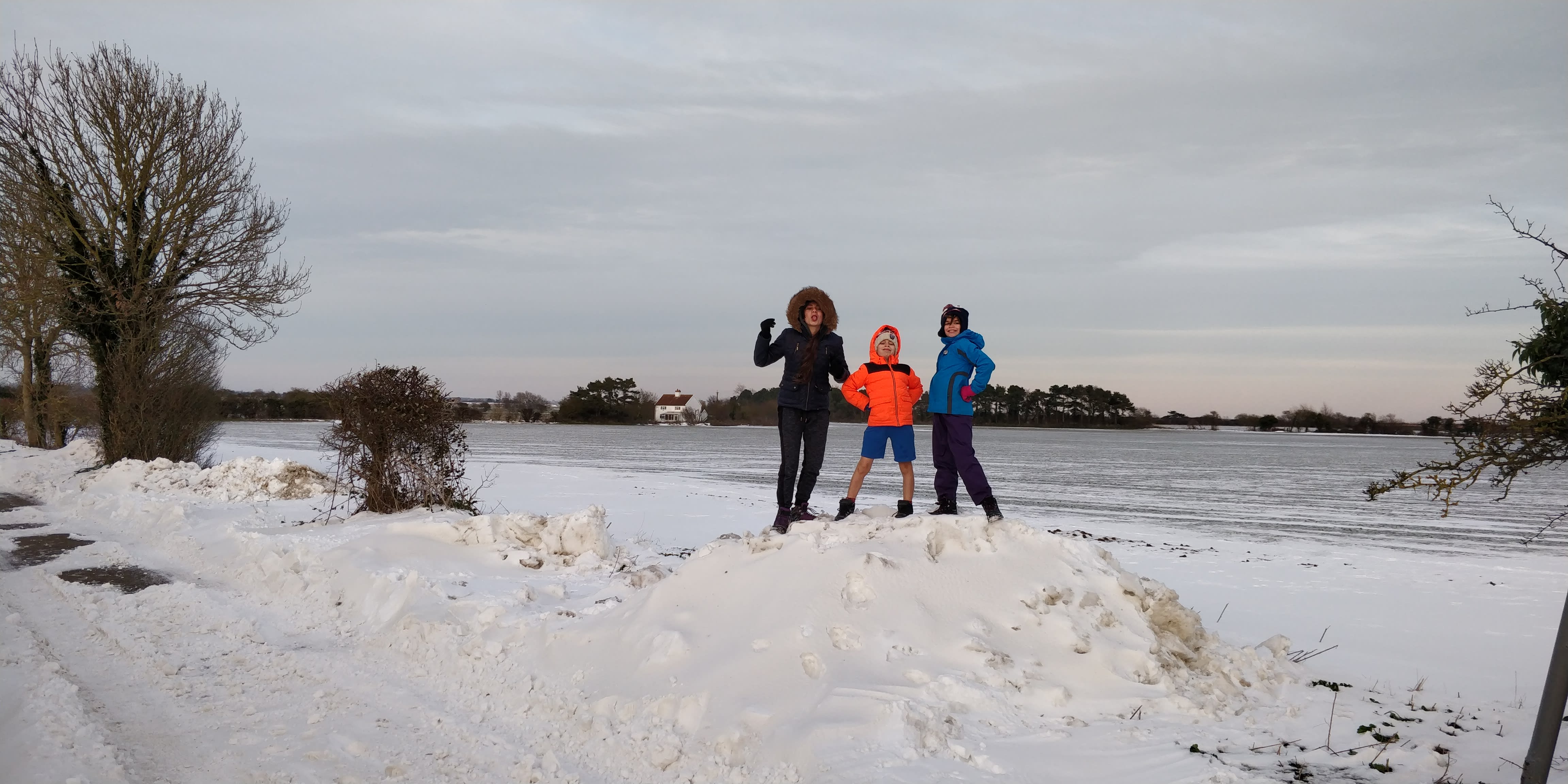 Our children ontop of a pile of snow