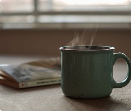 Imagen de una taza de café y un libro