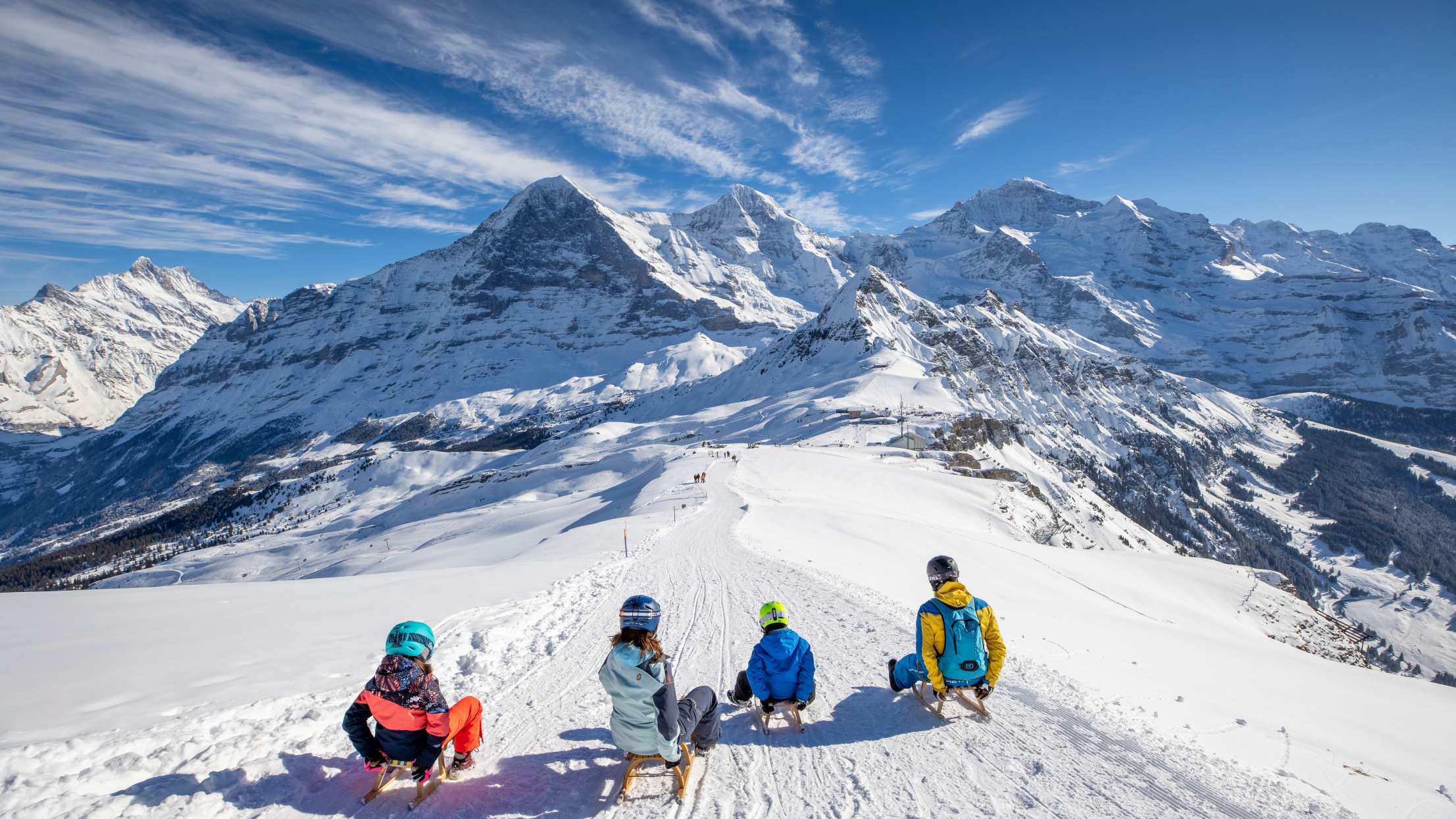 Maennlichen Familie Schlitteln nebeneinander Eiger Moench Jungfrau