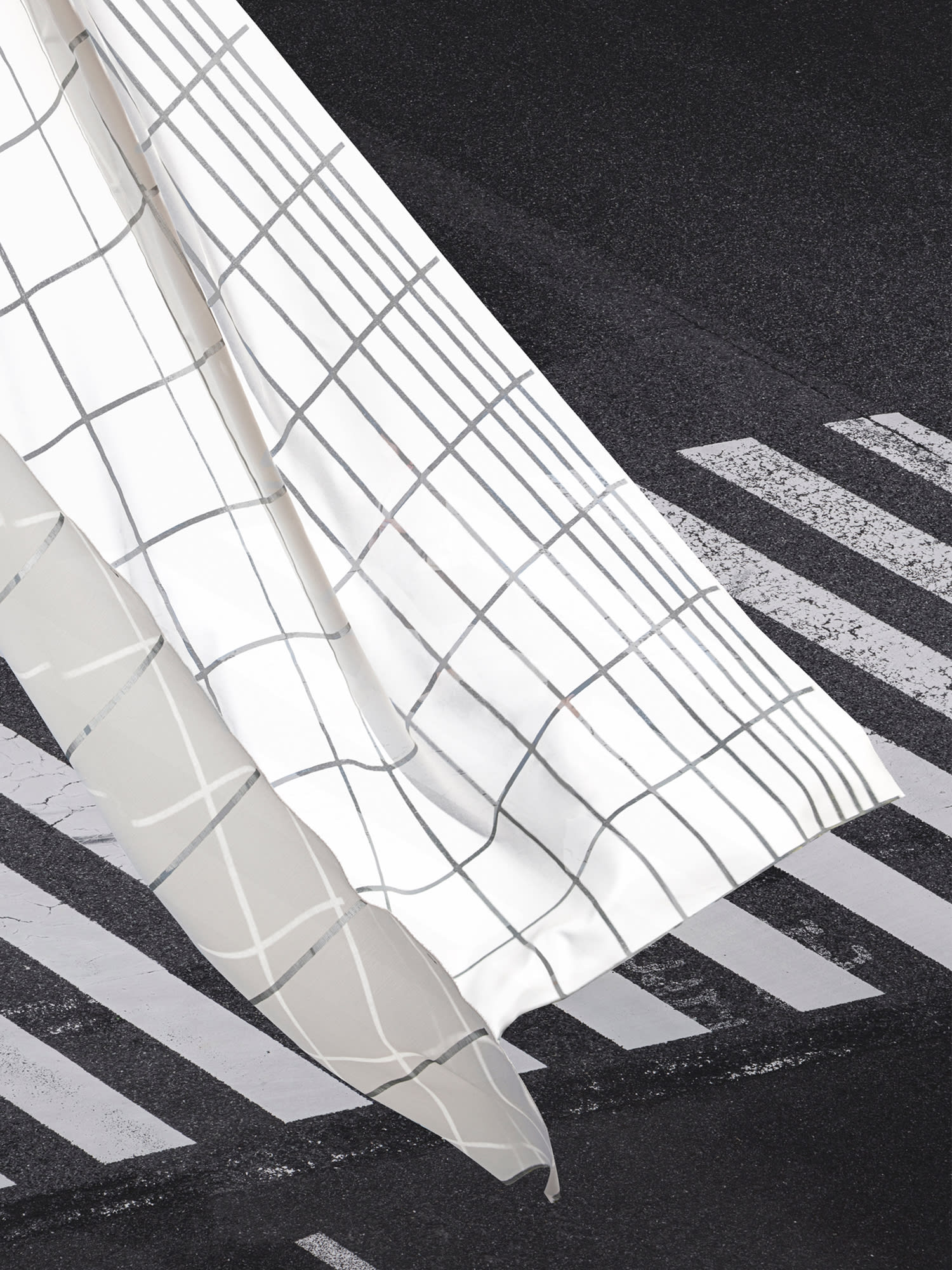 Key visual photography of a white, flying fabric over a street with zebra stripes.