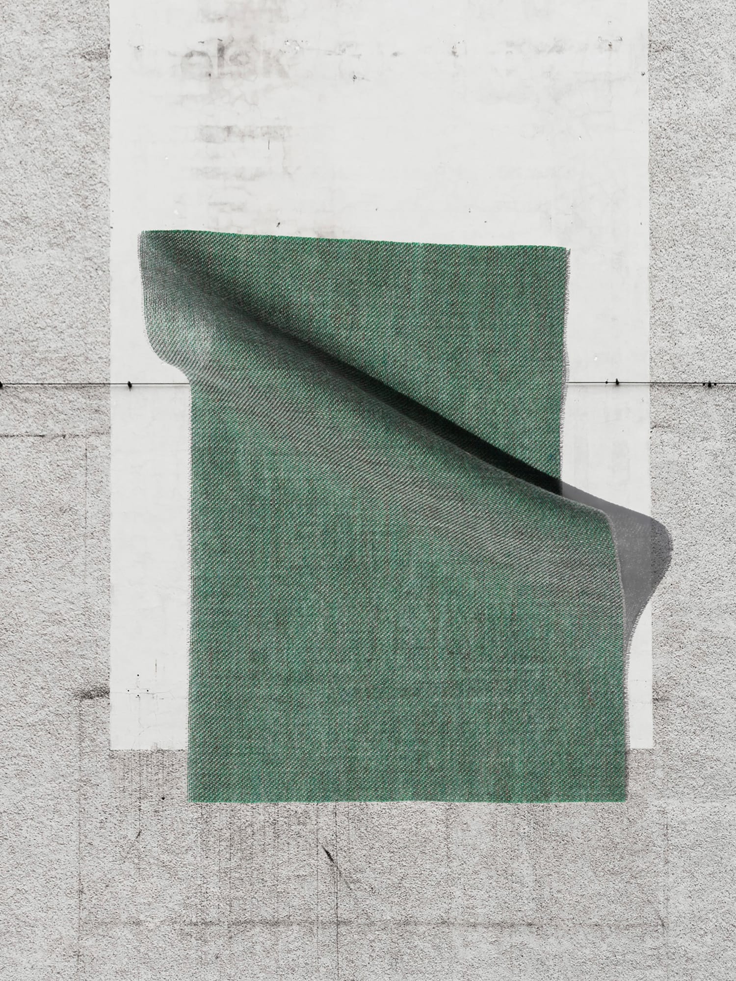 Draped green fabric sample on concrete floor