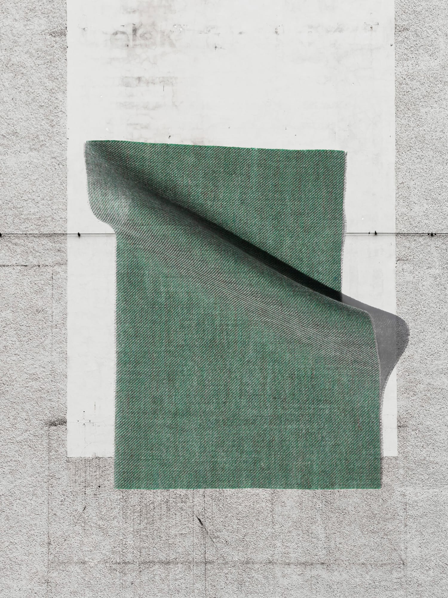 Draped green fabric sample on concrete floor