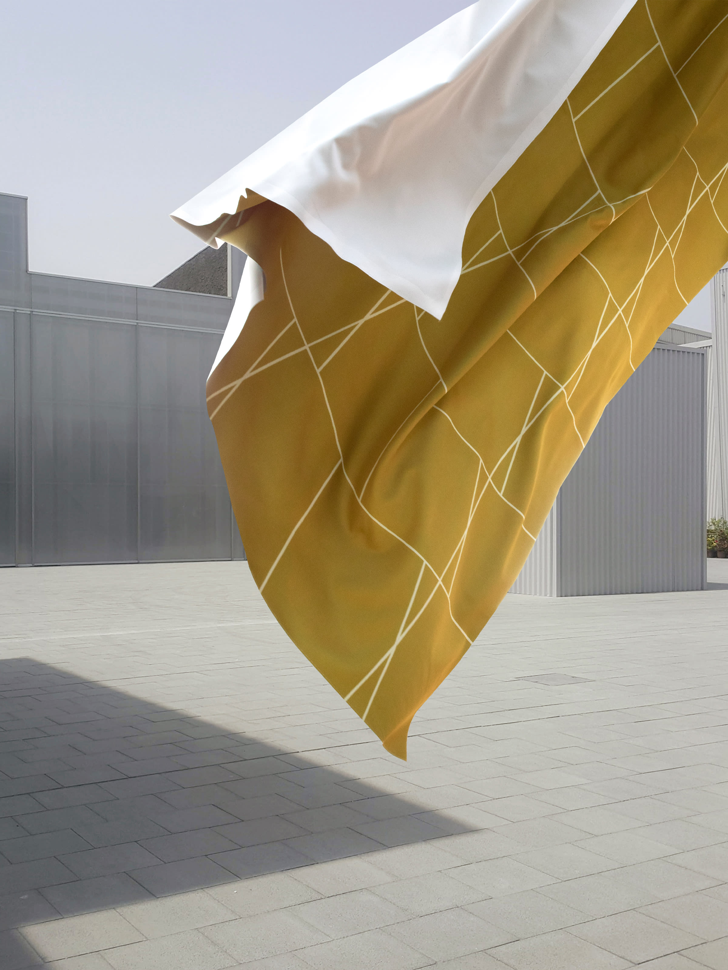 Key visual of a flying yellow fabric in front of a metallic building facade