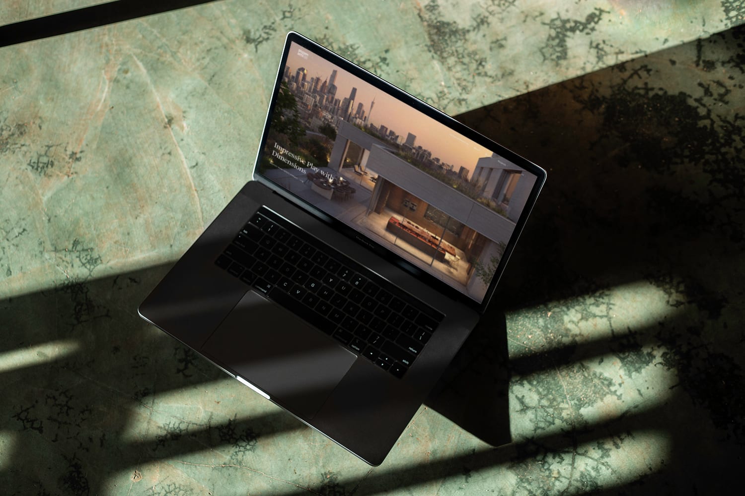 Website in a laptop mockup on green ground with strong shadow and light play