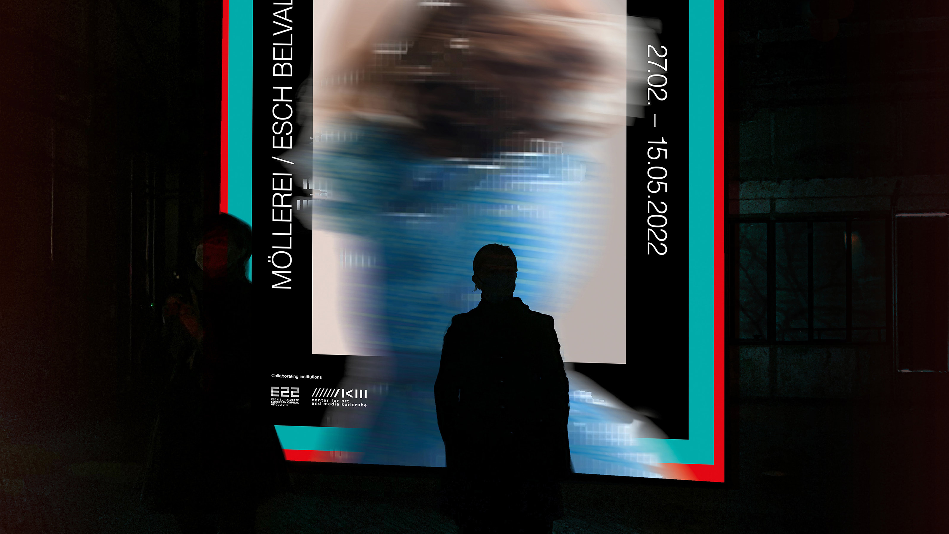 Silhouette of a person in front of a ZKM poster