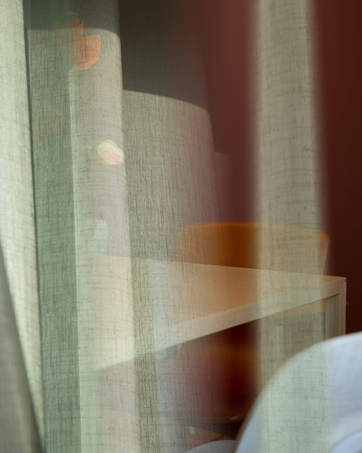 Double exposure of a green curtain and a room with table and chair. Photography for the campaign.