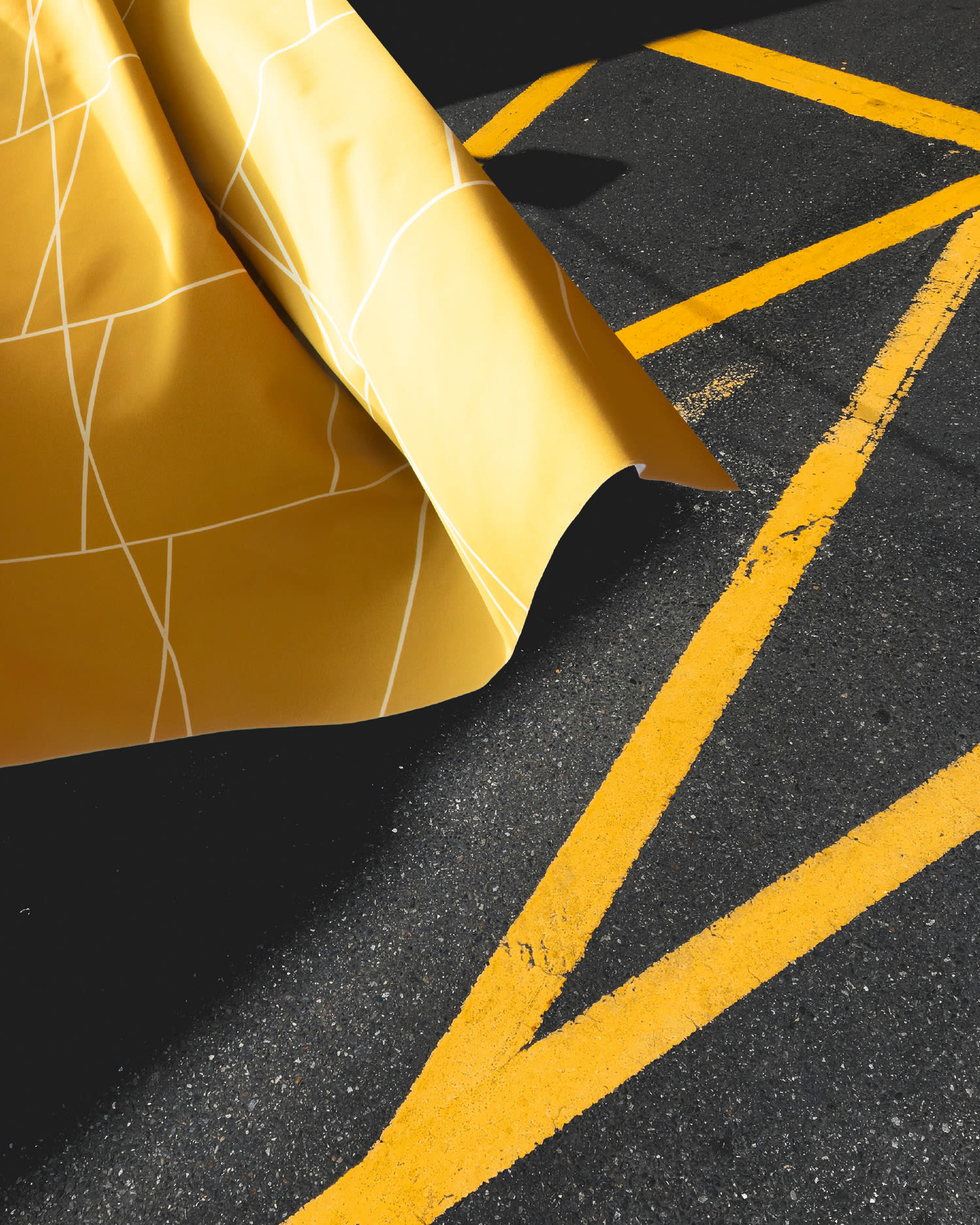 Partial section of a flying yellow curtain on a parking garage floor