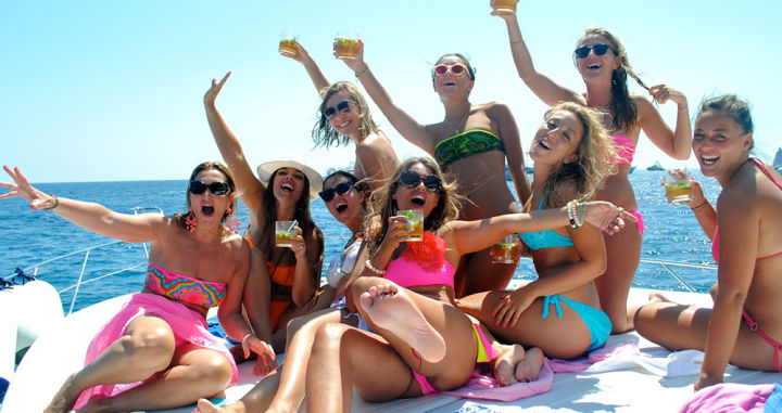 Cheerful woman on yacht with cocktails