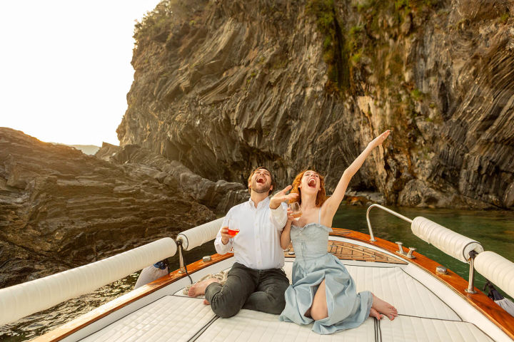 Cheerful couple holding glasses on boat