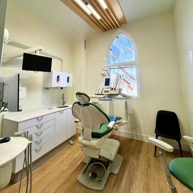 Dental office interior with natural light and a TV for patients.