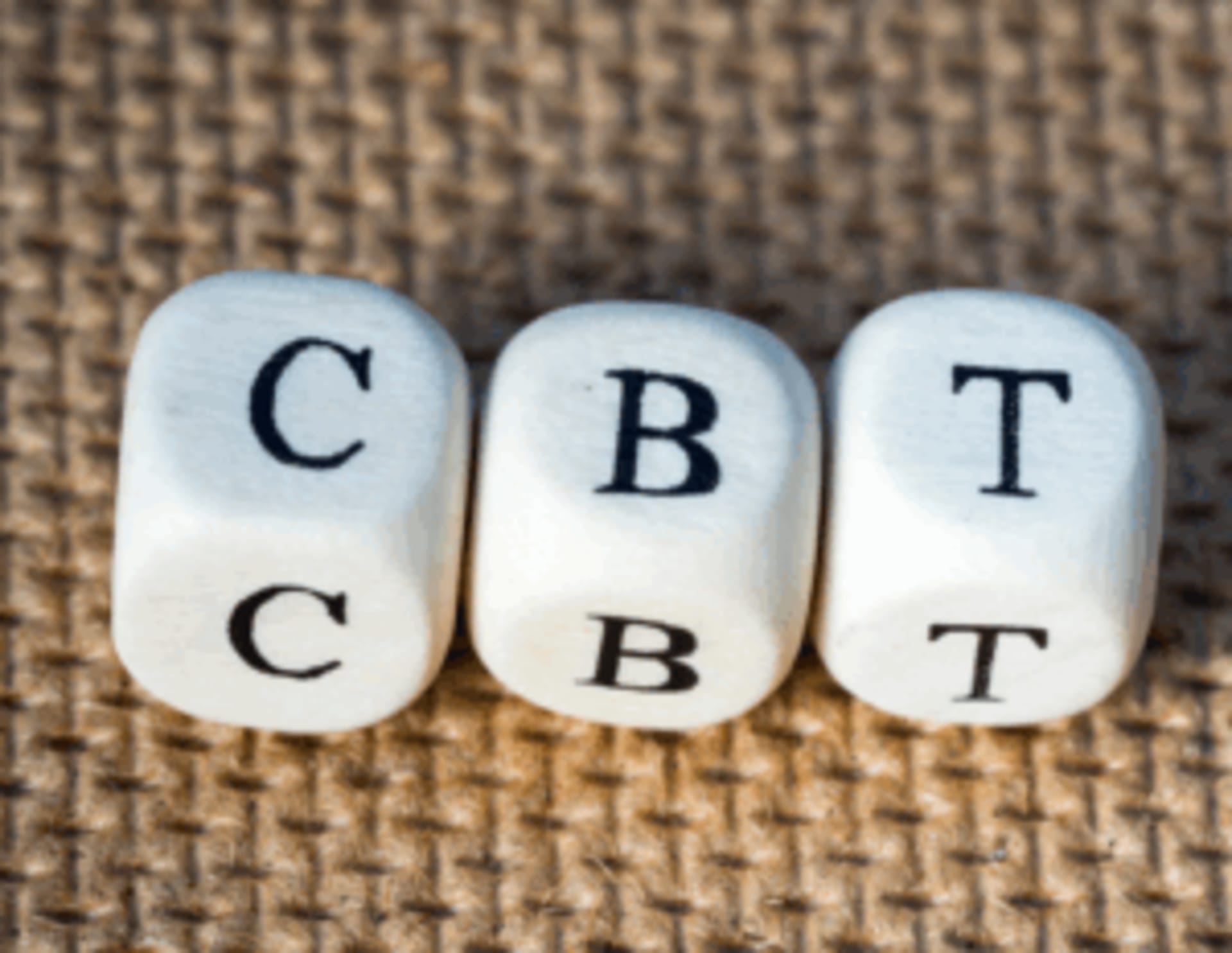 Three white dice with the letters "C," "B," and "T" are lined up on a textured background.