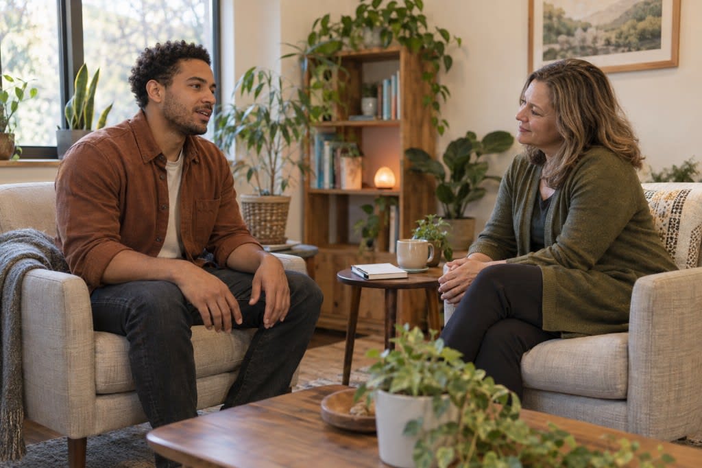 A client and therapist sitting across from each other in a warm office, practicing acceptance together