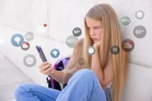 A picture showing a teenager using social media on their phone, highlighting the importance of parental guidance and involvement in addressing the impact of social media and mental health.