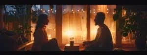 A man and woman sitting on the floor looking at each other, as if sharing a moment of introspection perhaps inspired by a comprehensive guide to couples counseling.