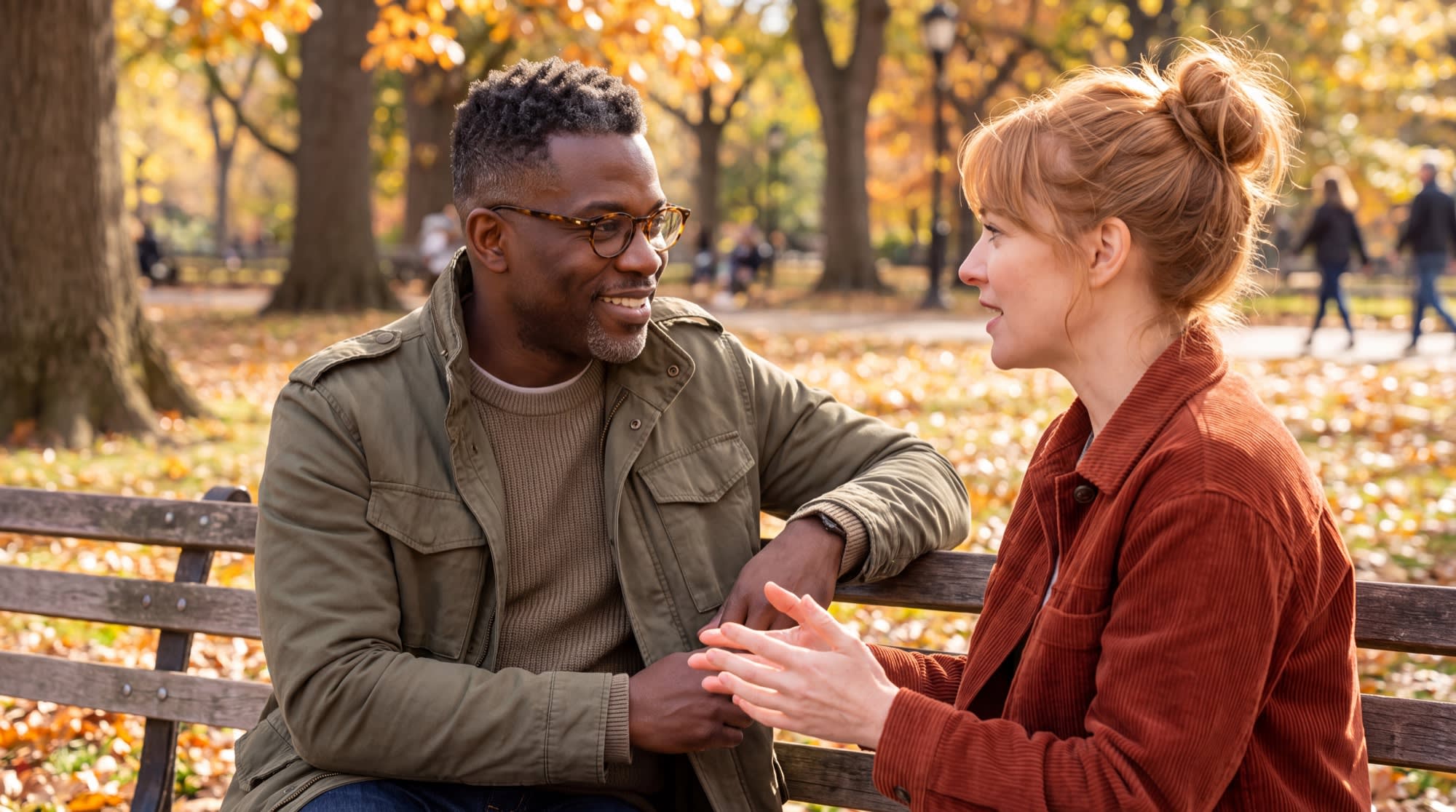 Two friends talking on a park bench in autumn, one listening closely as the other describes a confusing relationship.