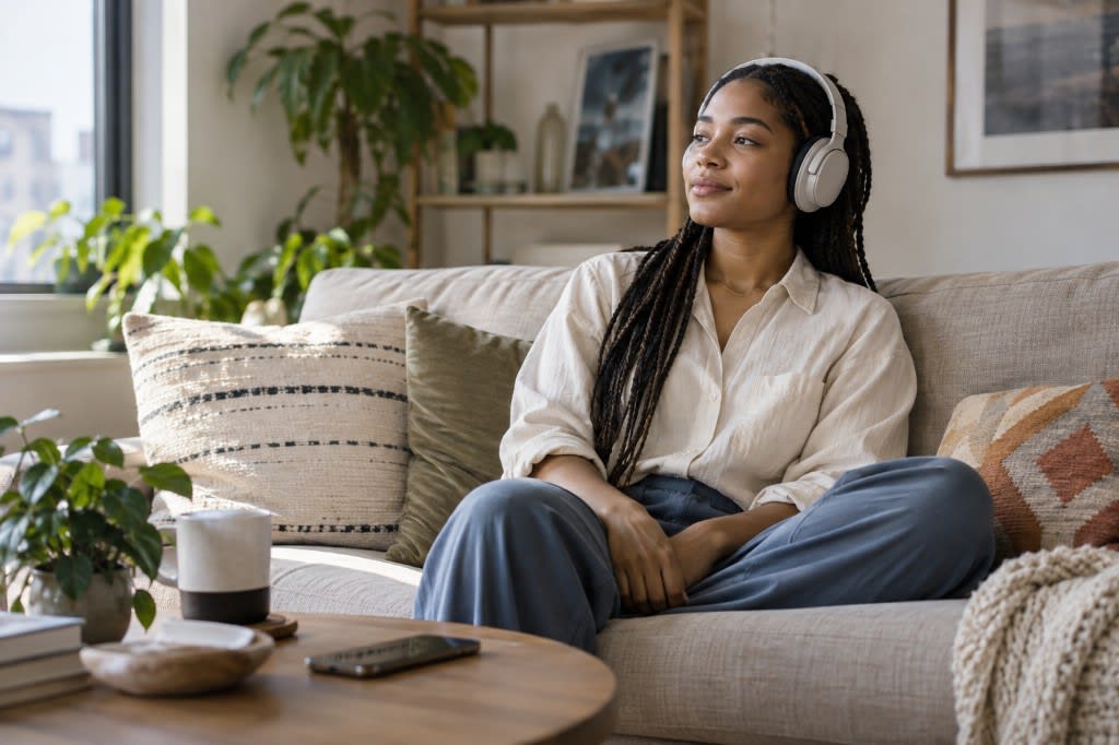 Guided meditation at home: listening to a practice on headphones on the couch