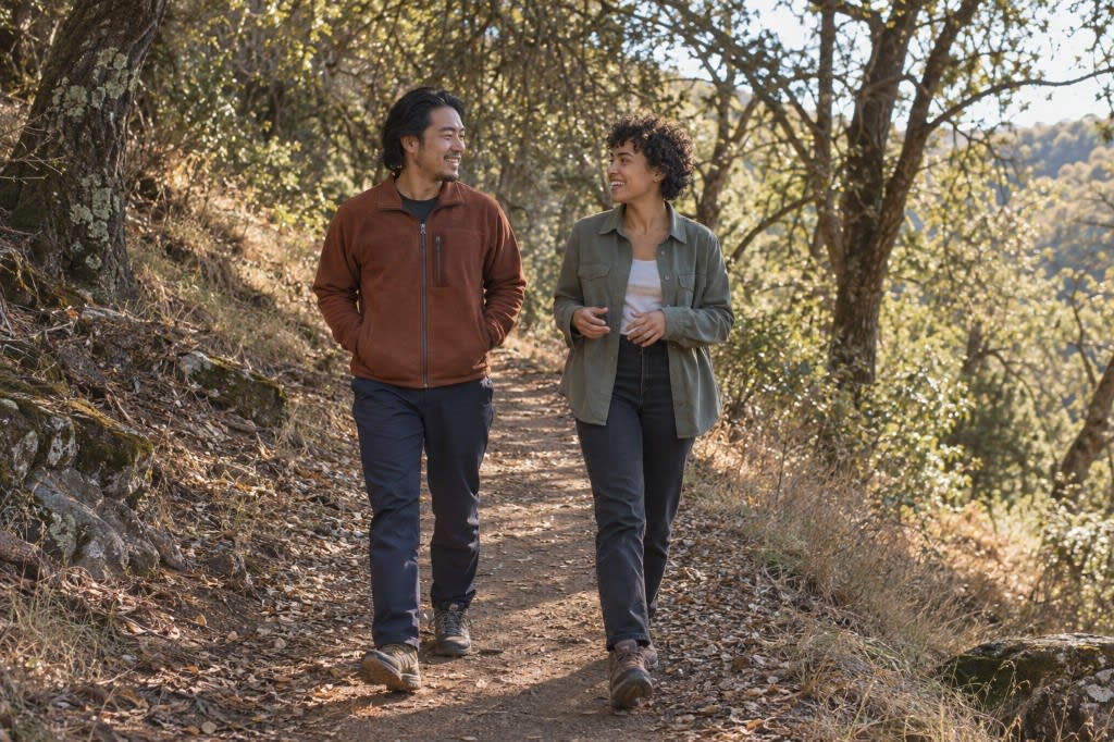 Two friends walking a wooded trail, showing gentle movement and connection as burnout self-care