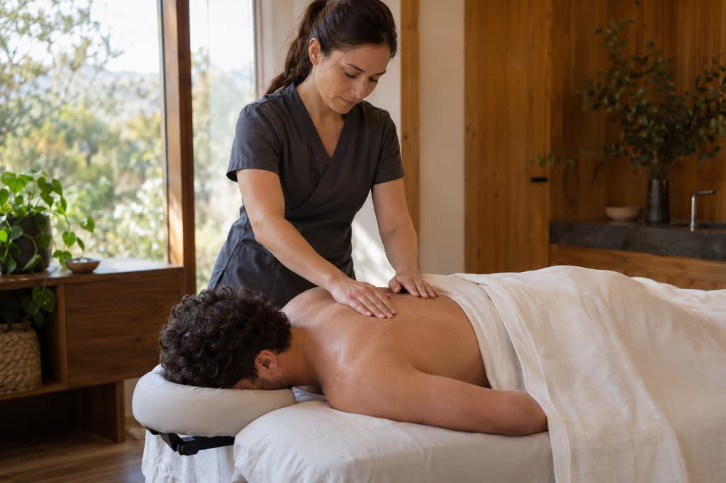 Therapist giving a restorative spa treatment in a sunlit wellness room