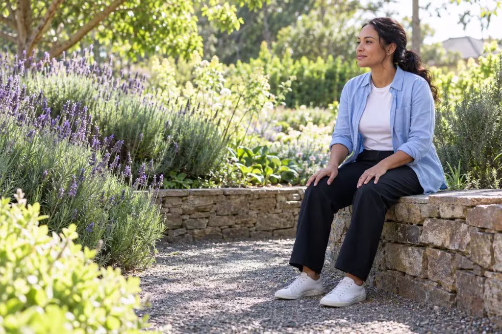 How to cultivate empathy without burning out: a woman sits quietly in a garden, pausing to notice her own feelings.