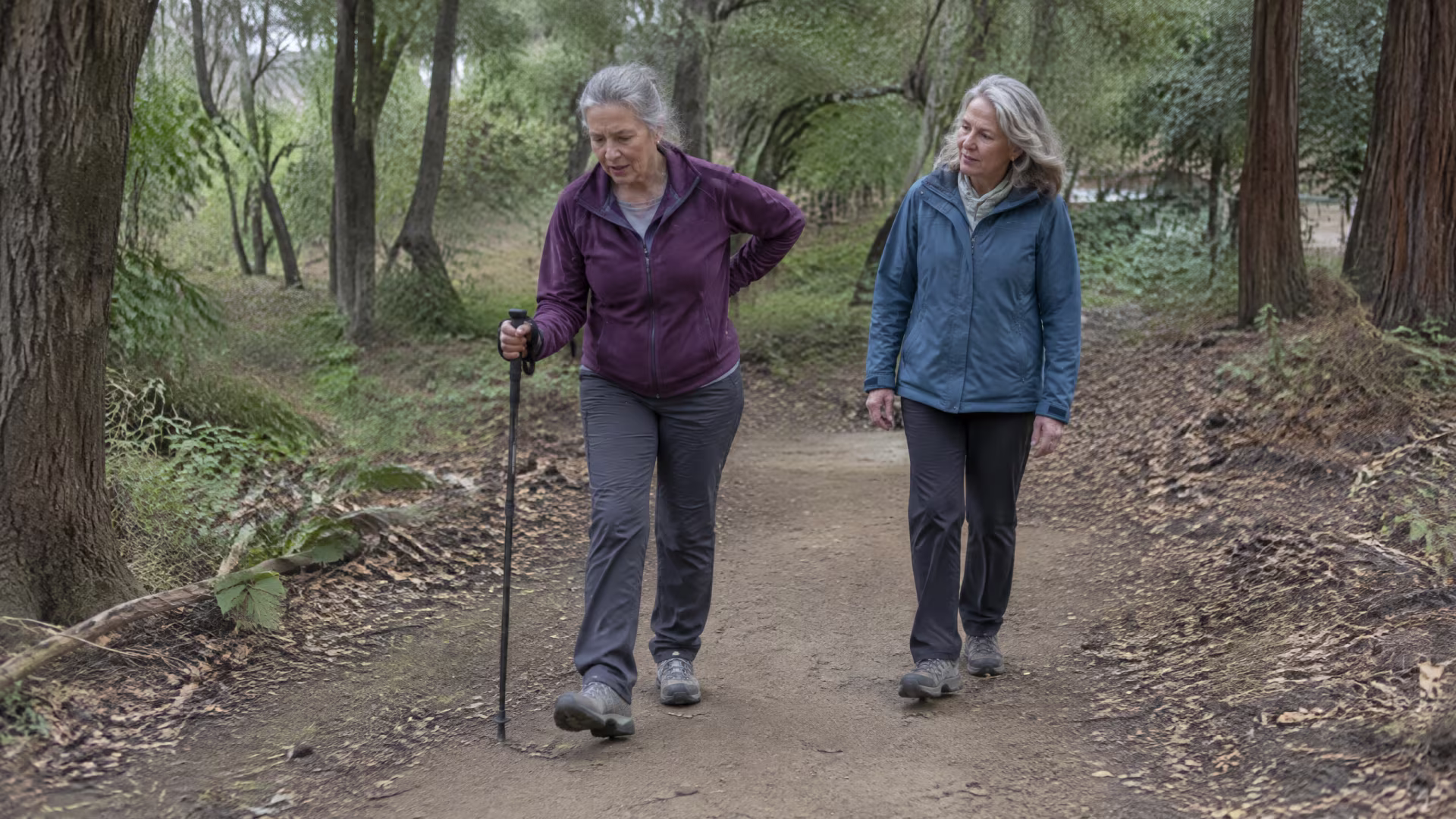 Older woman managing persistent physical discomfort from body grief while walking with a supportive companion