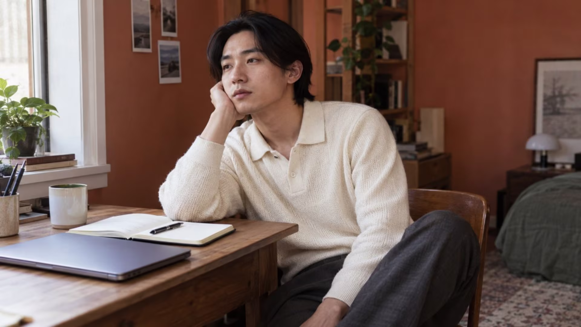 Man sitting at a desk with his chin in his hand, staring out the window with the mental fog of lethargy
